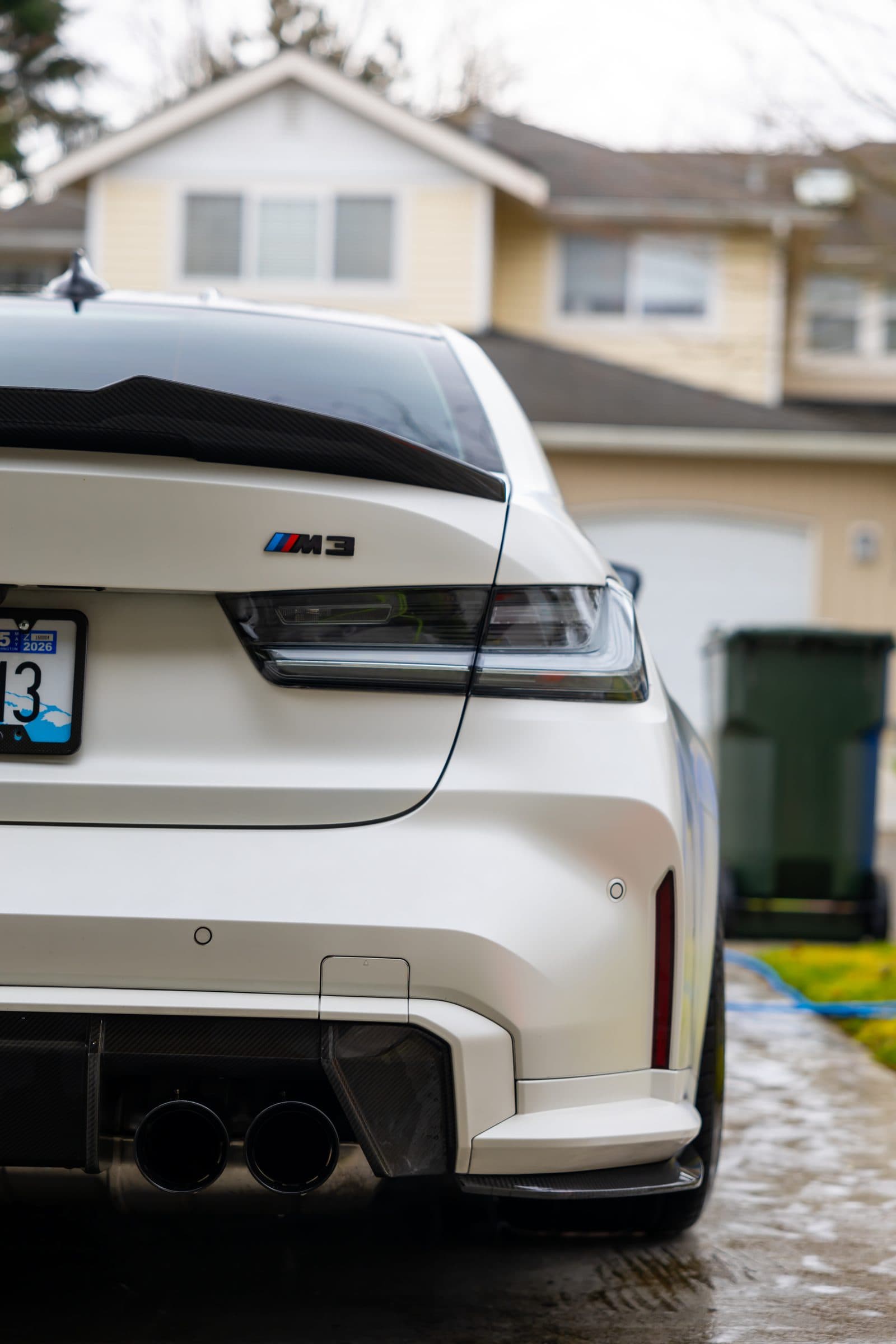 Rear view of a white BMW M3 after an exterior hand wash and detail