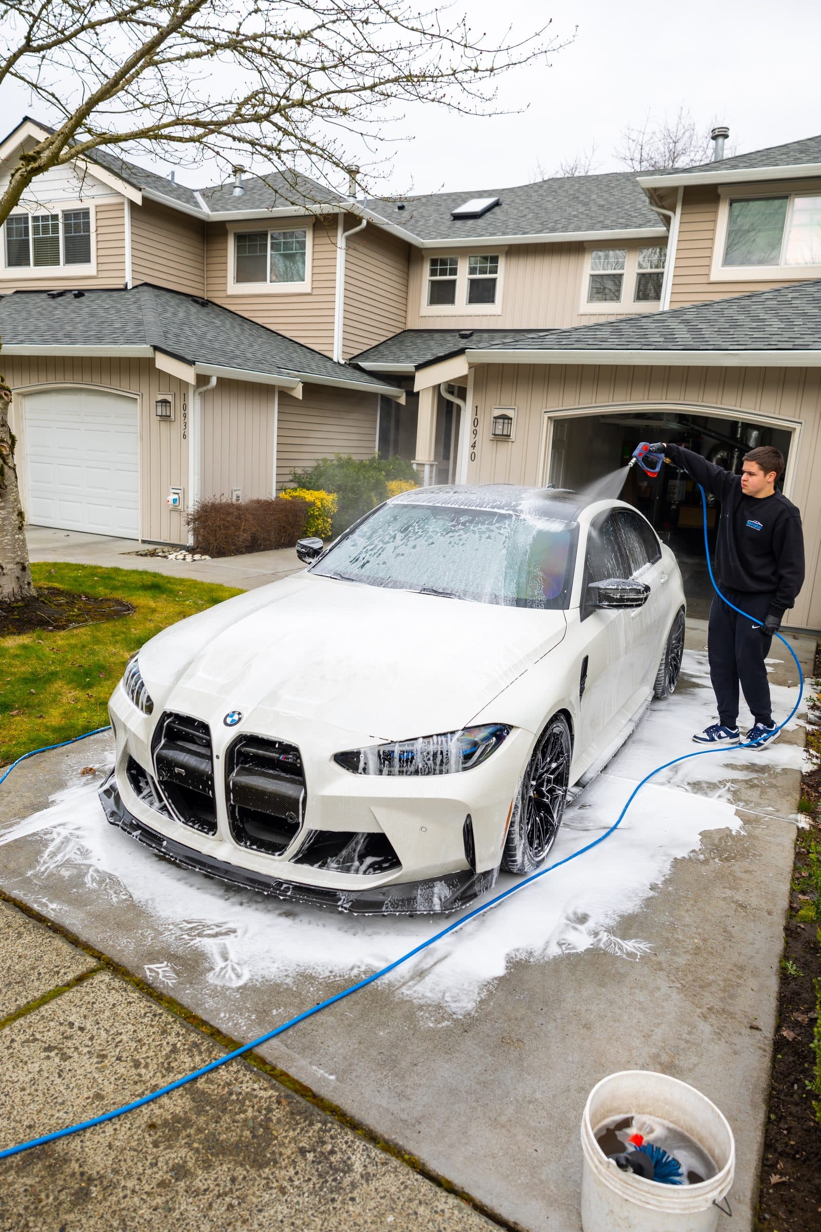 White BMW M3 covered in foam during a mobile hand car wash