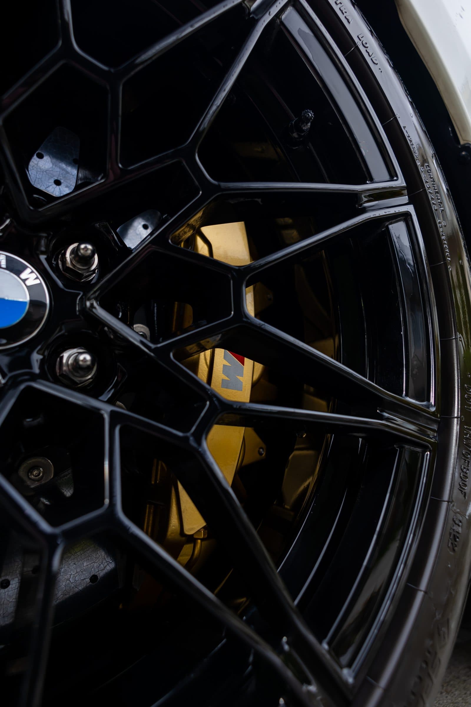 Close-up of a cleaned BMW M3 wheel and brake caliper after wheel detailing